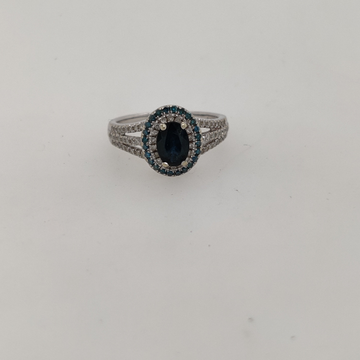 14K White Gold Sapphire Ring with Double Diamond Halo and Triple Shank; Size 6.75

Sapphire is 5x7.5mm; White Diamonds are approximately 0.68CTTW; and Irradiated Blue Diamonds are approximately 0.25CTTW
