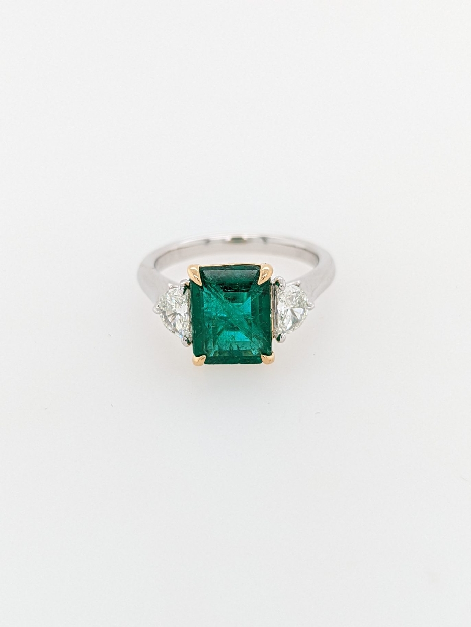 Platinum and 18K Yellow Gold 3 Stone Ring with Emerald Cut Emerald Center and 2 Half Moon Diamond Accents; Size 7
Emerald weighs 3.02CT
Diamonds weigh 0.54CT Total