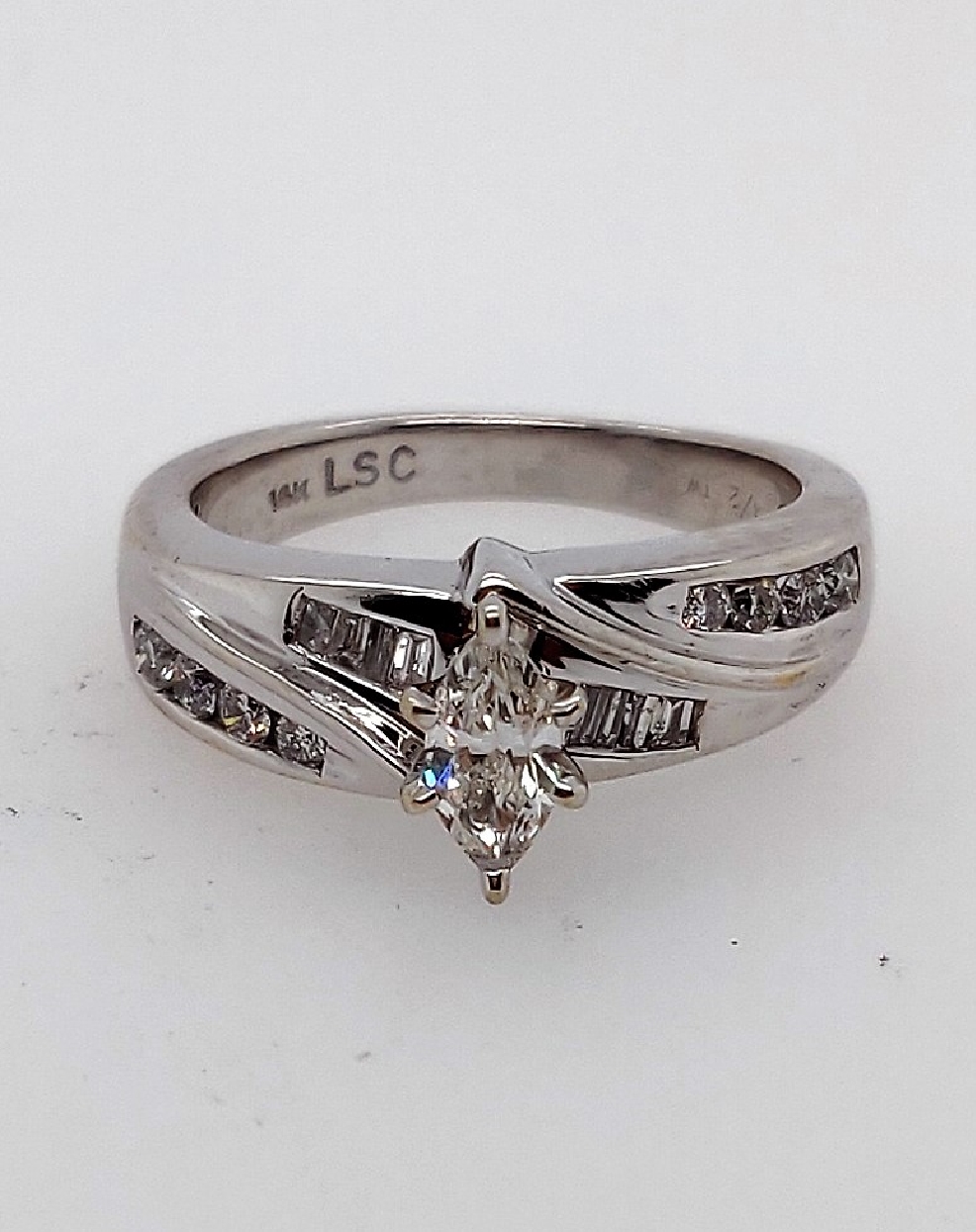 14k white gold engagement ring with prong set 0.32 marquis dia. center I1/J and approx 1/2 carat channel set round and baguette sides SI2-I1/ I-J. Size 5.25.
