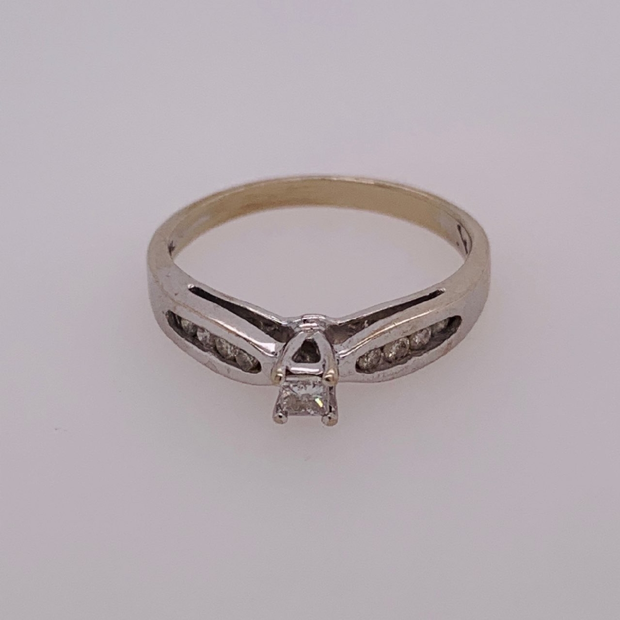 10k White Gold Engagement Ring with Princess Cut Center Stone in a Cathedral Setting with 8 round Diamonds on the Shank. Size 6