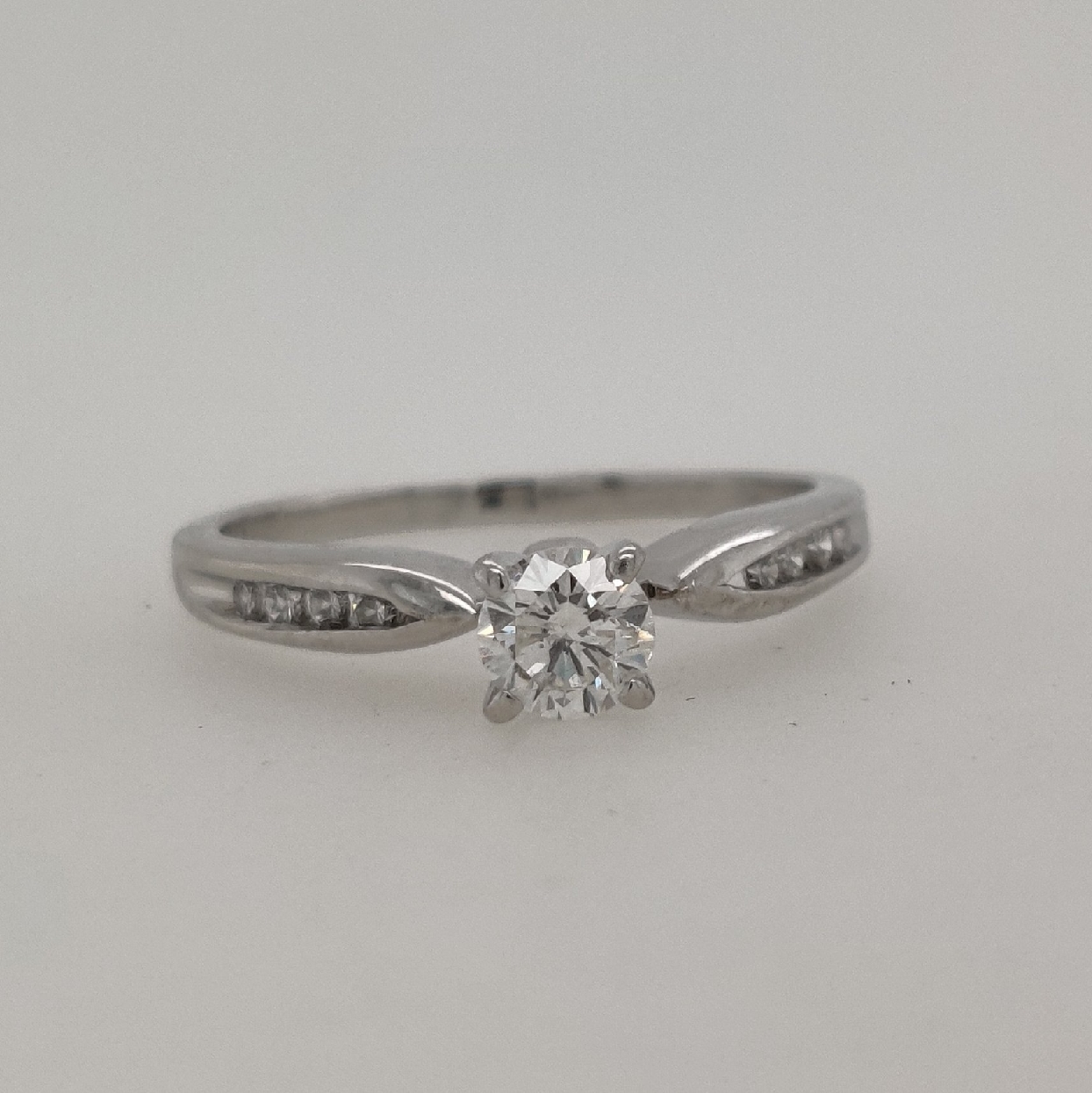 Platinum Solitaire Engagement Ring with Channel Set Diamonds on the Shank; Approximately 0.37CTTW; Size 5
Center Stone is approximately 0.27CT; H/SI2