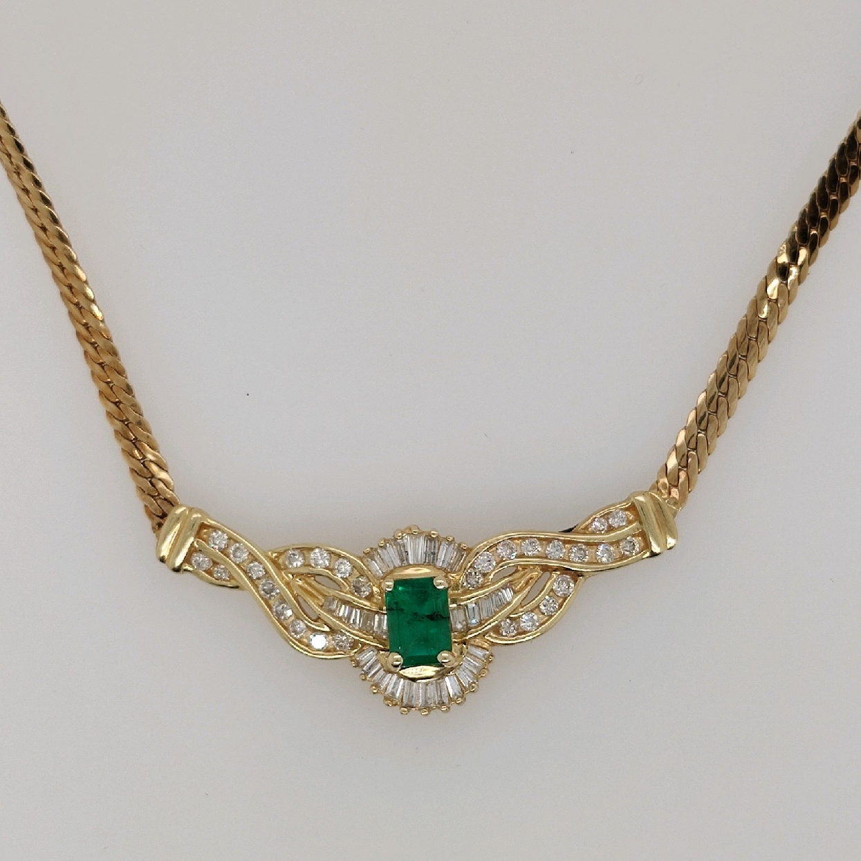 14K Yellow Gold Flat Woven Chain with Emerald and Diamond Pendant; 17.5 inches
Approximately 1CT Emerald
Approximately 0.94 CTTW Diamonds; H-I/SI2-I1

Appraisal on File