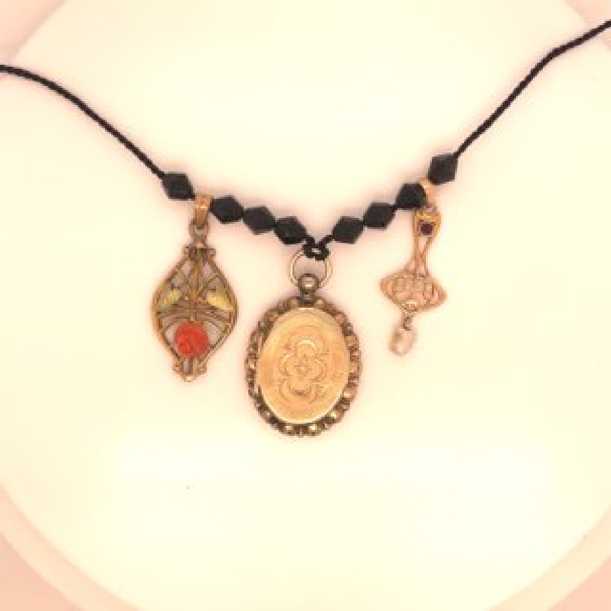 Victorian/Art Nouveau Assemblage/Morning Necklace. One Gold Filled Coral Floral Pendant; One 10K Amethyst and Pearl Pendant; One Gold Filled Morning Locket on Black Silk Cord with Jet Beads

Side Pendants Could be Seperated from Necklace and Sold Separatly. Contact for More Information.

Length: 20 Inches