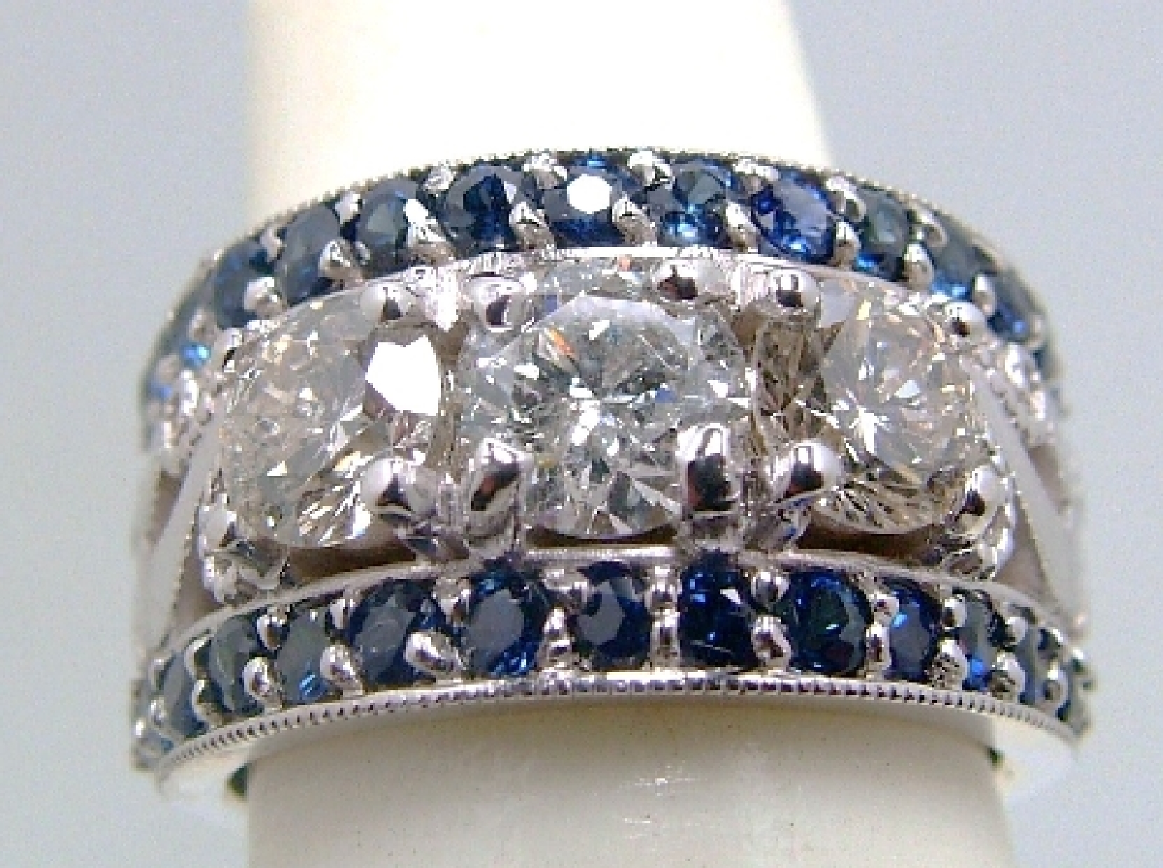 Ring w/ 3 round brilliant diamonds and 2 rows of round sapphires.