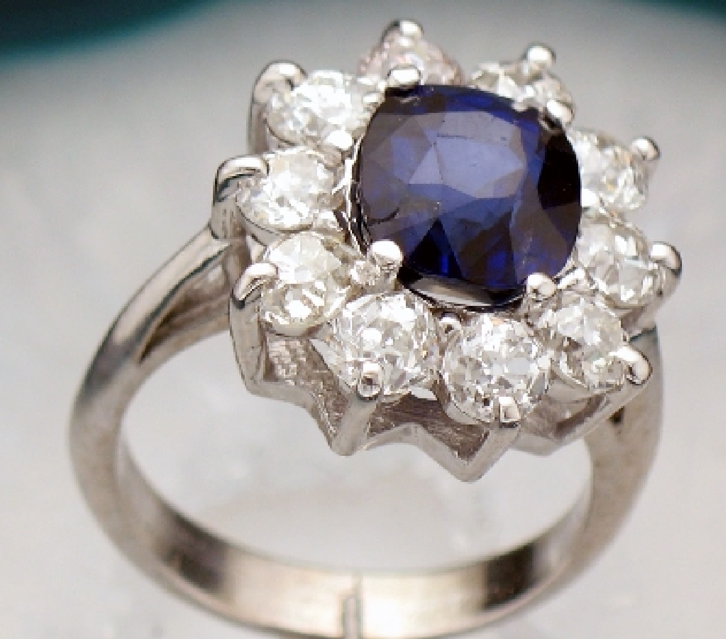 Princess Di ring with round sapphire and bordering diamonds.