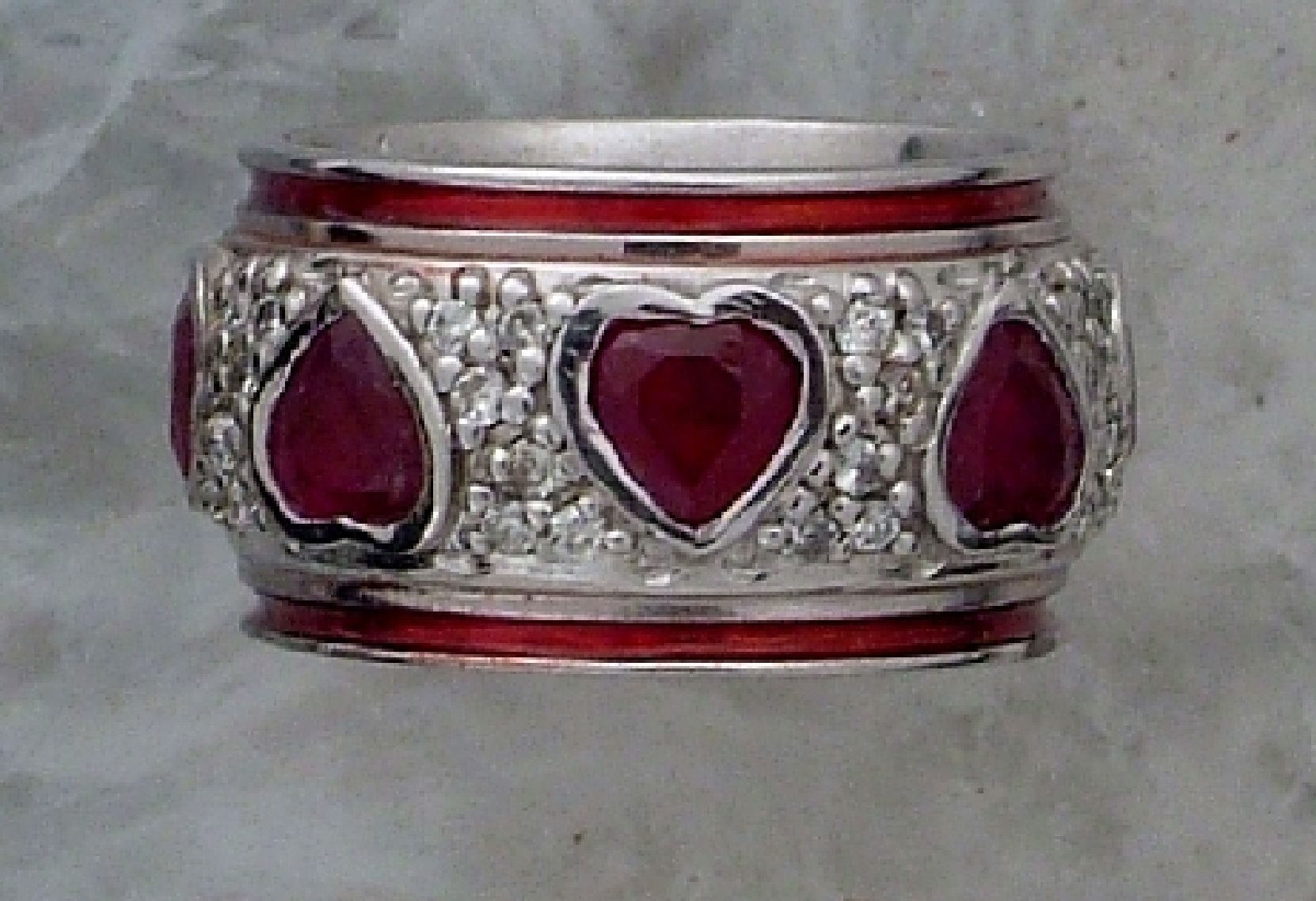 14K white gold band with ruby hearts and enamel highlights.