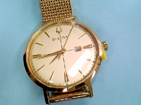 1802: One ladies yellow tone Bulova watch with day calendar mess bracelet 