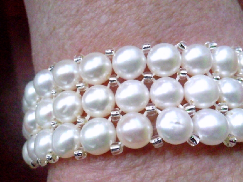 3781: One ladies 3 row  Freshwater button pearl strertched and silver tone glass bead bracelet