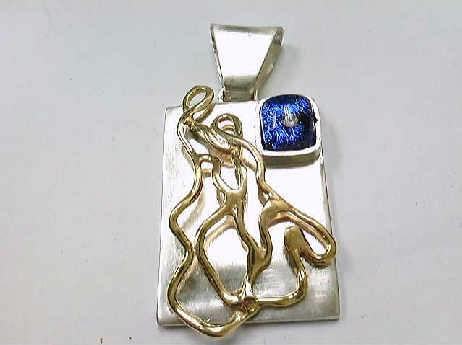 385: One custom made sterling silver retangular pendant with 14k yellow gold plated wire motif pinned to front
Set with a square diamond Inclusion tm blue dichoric glass stone 