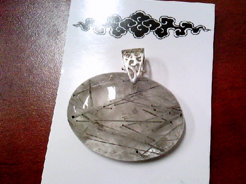 3974: One sideways oval shaped tourmalined quartz pendant on sterling silver