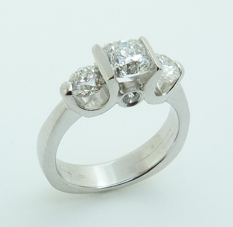 18K white gold three stone engagement ring;
set with an ideal Dream cut diamond by Hearts On Fire;
-centre: 0.903ct G; SI1 (DRM8480)
-accented with two ideal round brilliant cut diamonds by Hearts On Fire; 0.341ct I; SI1 (HOF112595) &
0.338ct H;