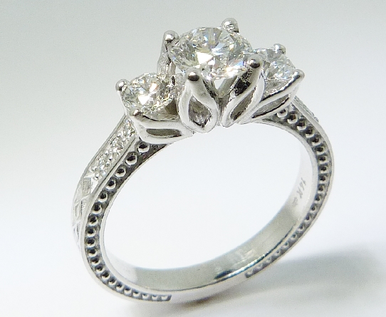 14K white gold floral detail engagement ring; set with an ideal round brilliant cut diamond by Hearts On Fire;
-centre: 0.548ct H; VS1 (HOF111258)
-accented with ideal round brilliant cut diamonds by Hearts On Fire; 0.24ct H; VS2 (HOF127956) & 0.2