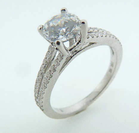 18K white gold engagement ring by Natalie K; set with 1.0 CZ. Accented with 50 G-H SI very good round brilliant cut diamonds totaling 0.26 carats.
