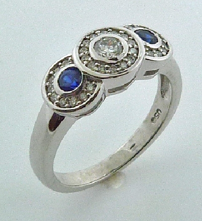 14KW Coloured gemstone lady s ring set with: - - 0.166ct excellent cut diamond; E/F; VS2 - - 2 blue sapphires; 0.255cttw - - 32 round brilliant cut diamonds; 0.17cttw; G/H; SI1