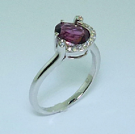 14 karat white gold coloured gemstone ring. - Set with one 1.72 carat Rhodolite Garnet. - Accented with diamonds; 0.071 carat total weight.